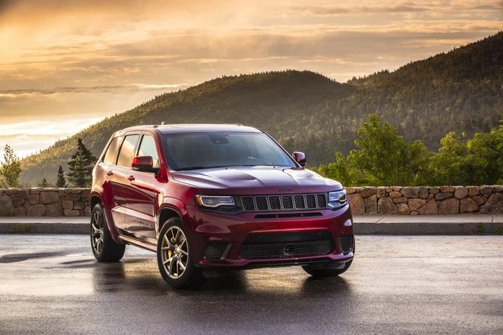 Red 2021 Jeep Grand Cherokee in a mountain landscape.
